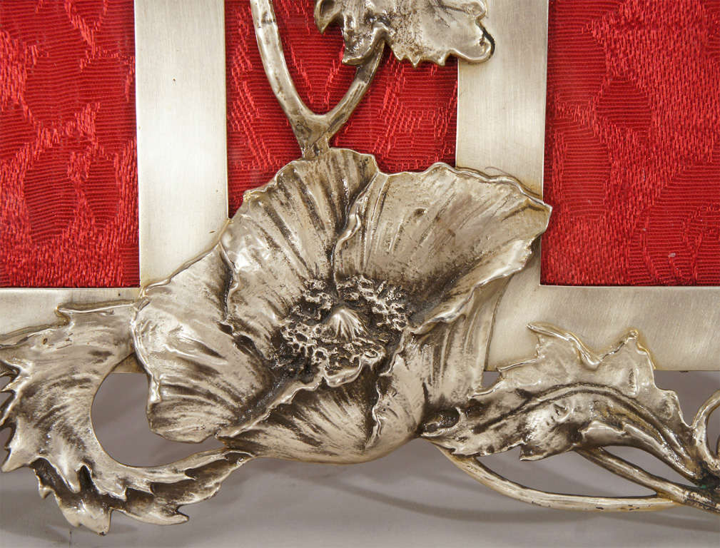 An outstanding example of the Art Nouveau style is embodied in this double picture frame. Realistic poppies in all stages of blooming surround and support this magnificent sterling silver piece which hardly needs any pictures!