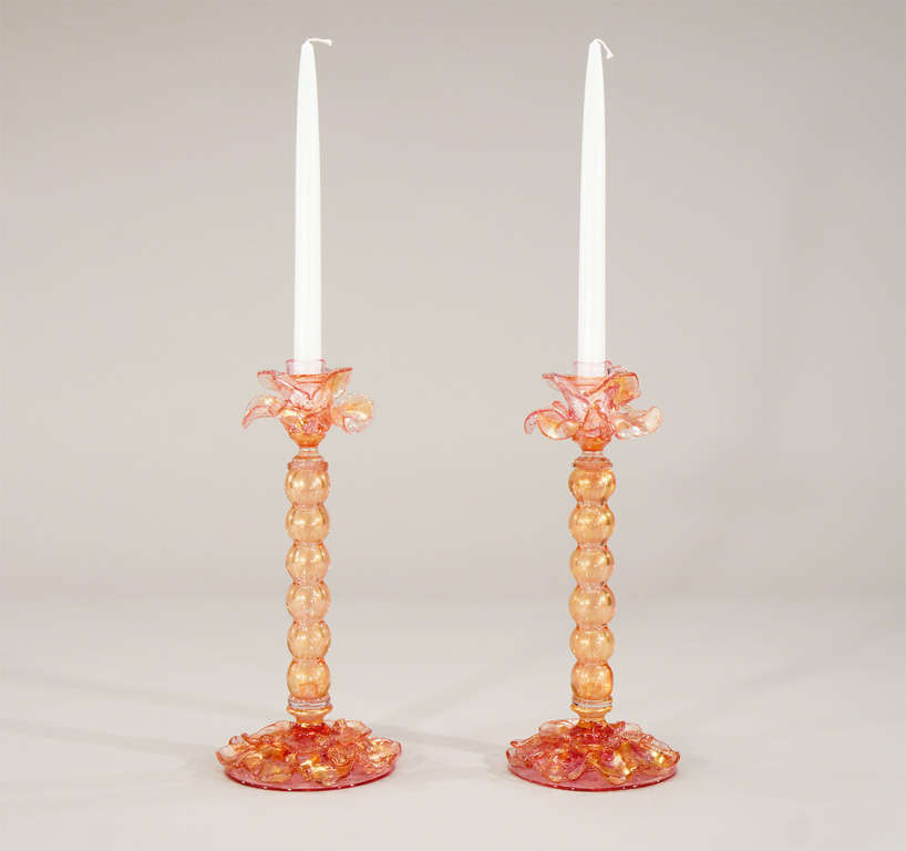 A wonderful pair of tall "floriform" hand blown Venetian candlesticks evoke the image of flowers opening into the candles.Filled with gold leaf inclusions, the candlecups are made as flower petals and the bases have applied petals