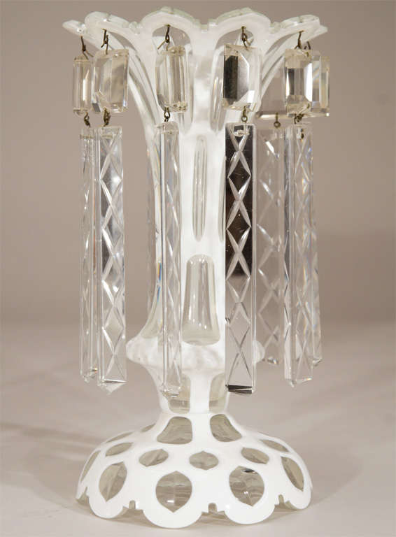 A lovely pair of hand blown crystal lustres with raised petal cut foot and notched rims. The lovely elegant shape of the vase, rises up to a flared opening. Cased in white and cut to clear, these will match any decor and the shaped prisms add to