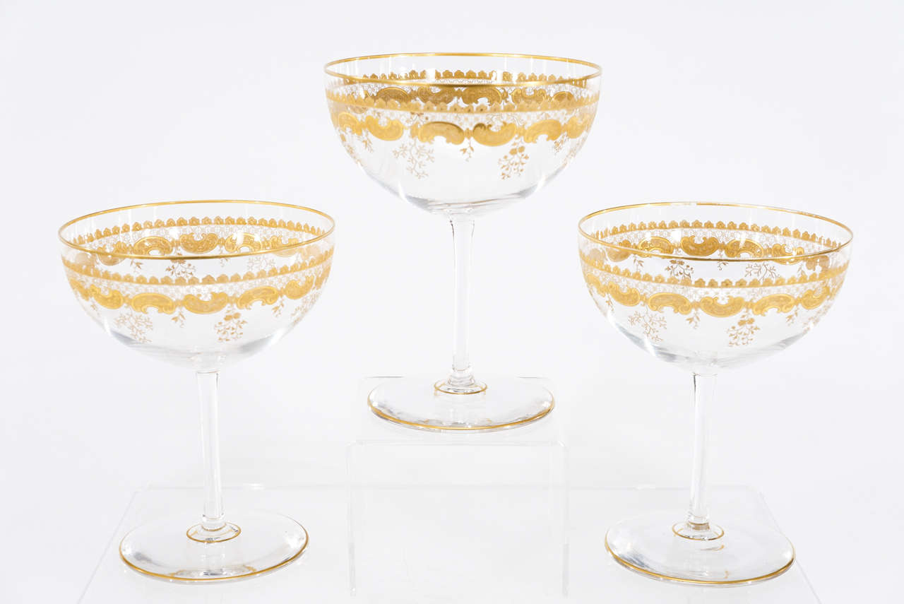 This perfect set of 12 hand blown crystal footed dessert compotes or Supremes is the perfect compliment to any table setting. The neutral clear crystal is embellished with an engraved scrolling pattern and finished with raised gilt decoration. The