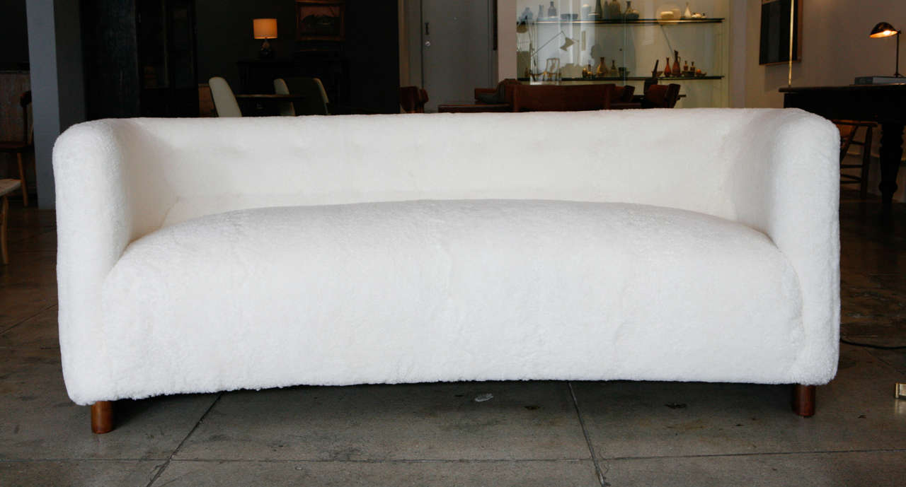 Fritz Hansen beautifully curved sofa in sheepskin with darkened beechwood frame. The sheepskin is newer to the piece by a few years, immaculate.