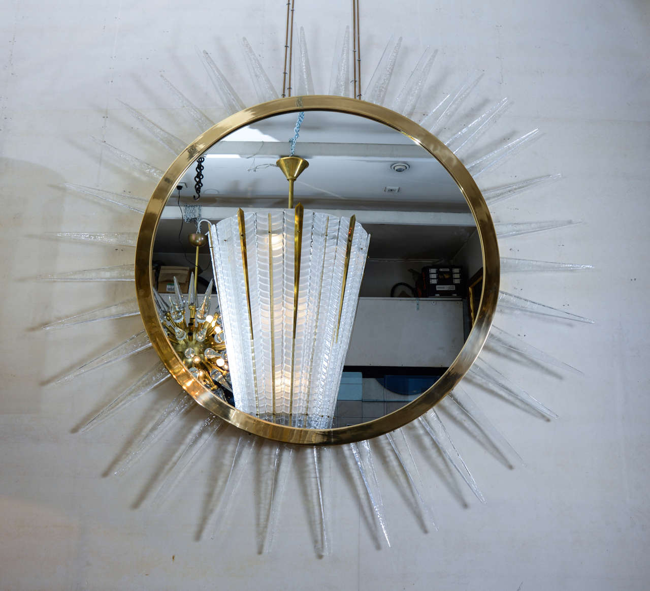 Large sunburst mirror with polished brass fixture and glass pieces.

Possibility of a second one or glass in an other color.