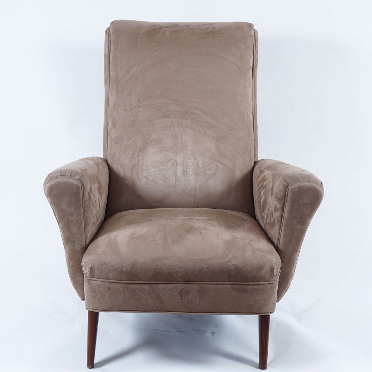 These wonderful chairs are as comfortable as they beautiful. Great form and somewhat recent re-upholstery in a rich tan/taupe ultrasuede enhance the appeal of these lounge chairs. Likely of French origin in the 1940s, with walnut legs that provide
