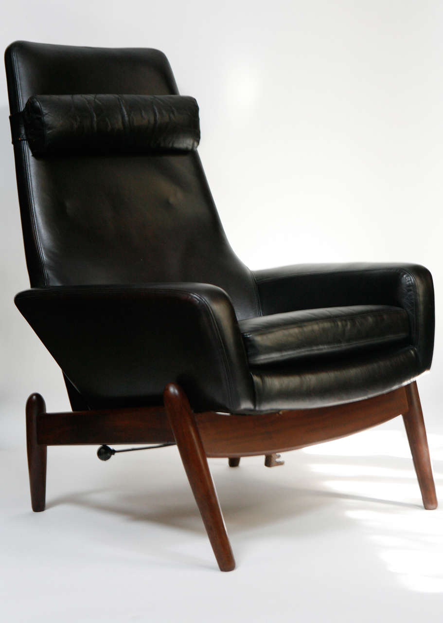 Lounge chair and ottoman designed in the 1960s by Ib Kofod-Larsen (1921-2003). Chair reclines and ottoman adjusts. Removable headrest cushion. Teak and black leather. Outstanding set.