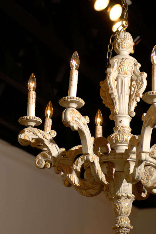 A French Rococo style carved, painted and parcel-gilt wooden eight-light chandelier from the 19th century, with scrolled arms and acanthus leaves décor. Born in France during the 19th century, this elegant chandelier features a central carved stem,