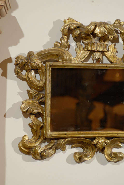 A pair of Italian Rococo style carved giltwood mirrors from the late 19th century. Each of this pair of Italian mirrors features an exquisite Rococo style giltwood frame, adorned with acanthus leaves and scrolls. Their horizontal format is accented