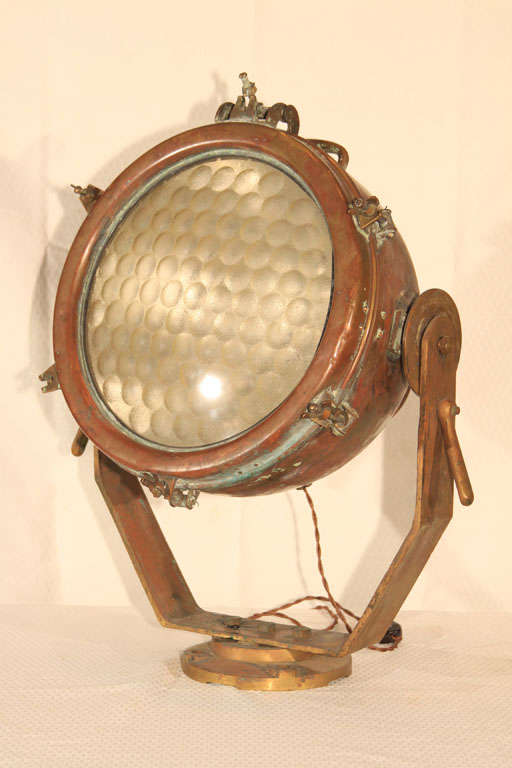 Old Copper Industrial Spotlight, most likely from an old tugboat or other maritime vessel;  this is rewired using a cloth-covered cord with on-line switch;  restored for use with a standard bulb.  Perfect as a striking table lamp or mounted on an