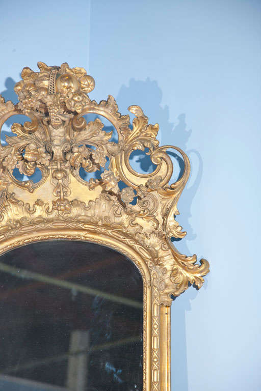 Spectacular antique French gilt and carved vertical wall mirror with foliate and cornucopia motif. Condition excellent.