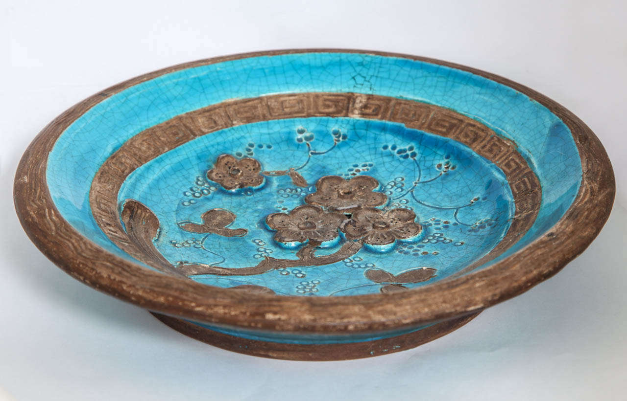 Zaccagnini art pottery dish inspired by Chinese antiquities. Features a cherry blossom tree at center depicted in bas relief, surrounded by concentric, patterned bands in key and wave motifs. Exquisite detail and color. Signed 