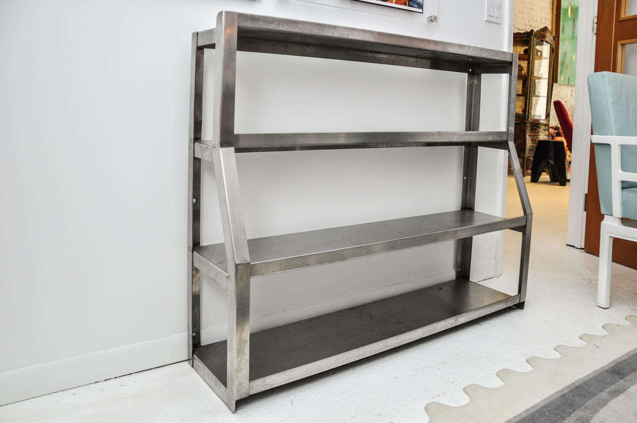 A great shelving unit for display! Made of stainless steel, this piece features 4 shelves of varying depths.