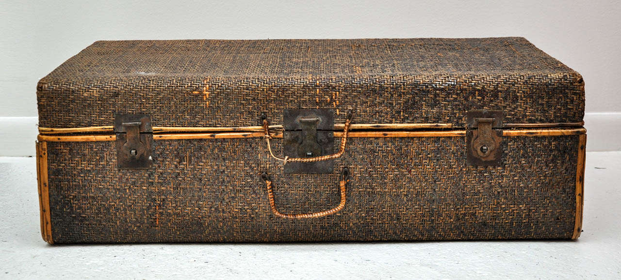 Wicker suitcase with vintage charm. Features paneled wood interior.