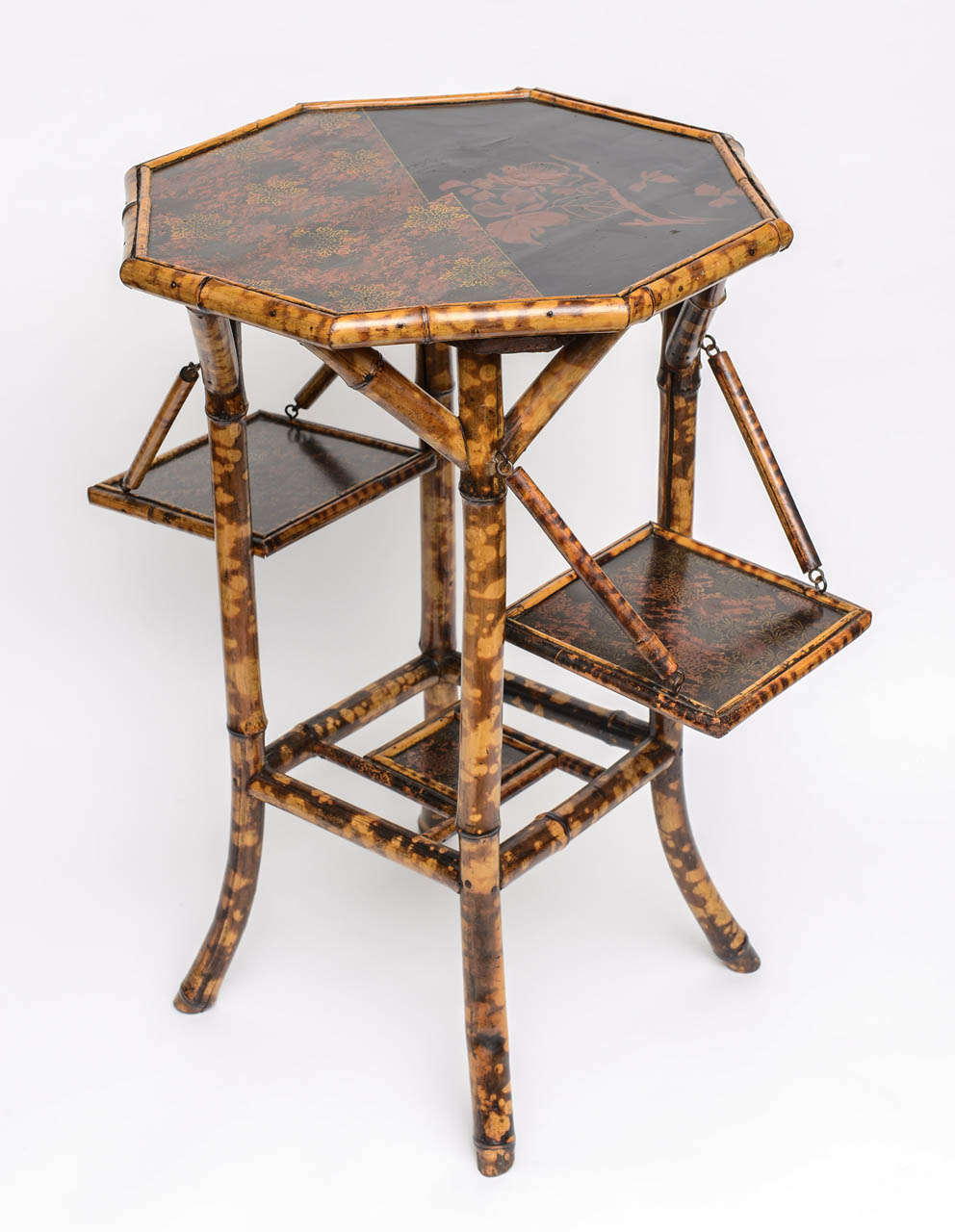 A lovely 19th Century English Bamboo side table with beautiful japanning and two side panels that fold up and down.