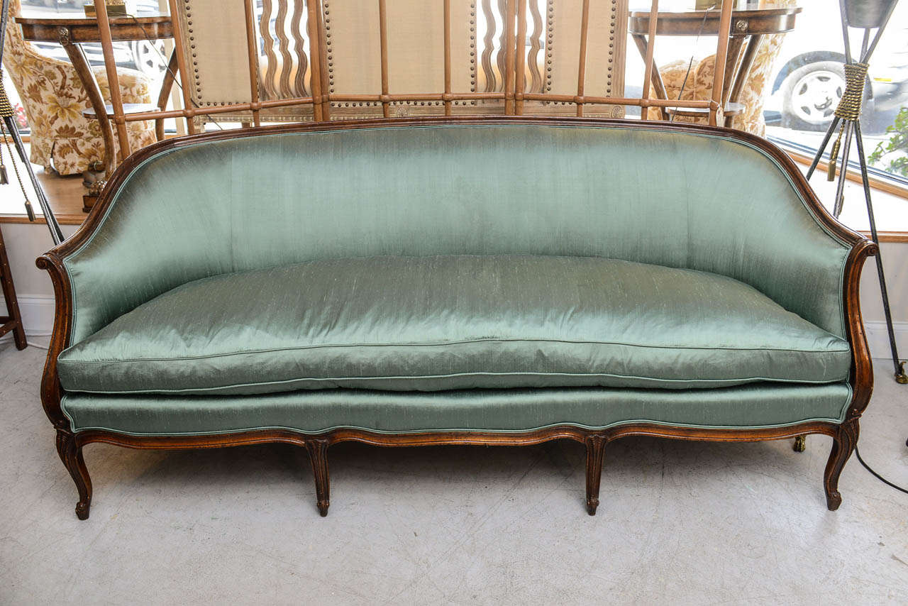 Elegant Louis XV style sofa newly upholstered in Dupioni teal silk fabric with a single down cushion.