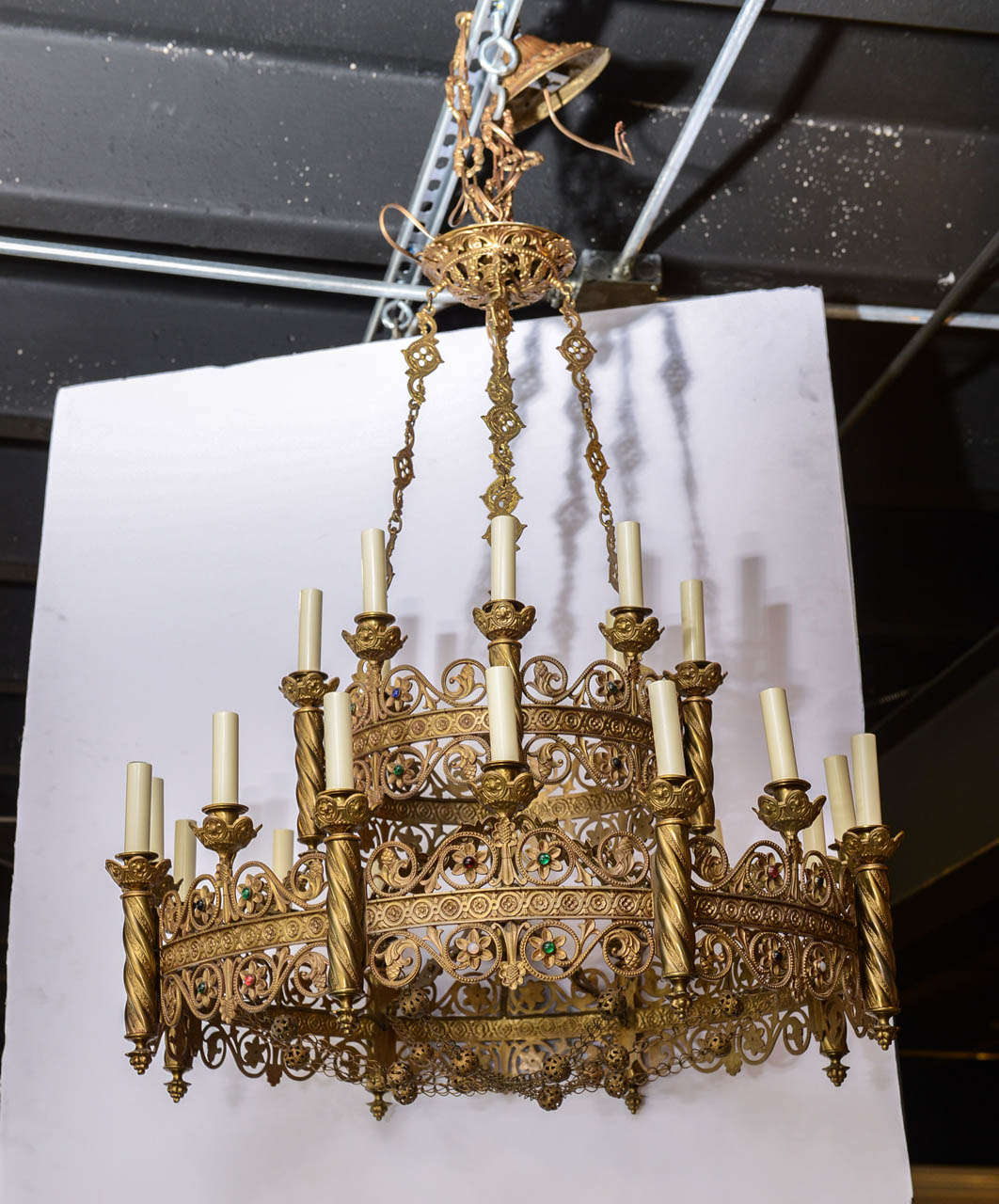 Grand scale Moorish bronze fixture with great attention to detail including multi colored studded stones.  This magnificent chandelier consists of two tiers and twenty four lights.  
The main body of this fixture measures 30 inches in diameter and