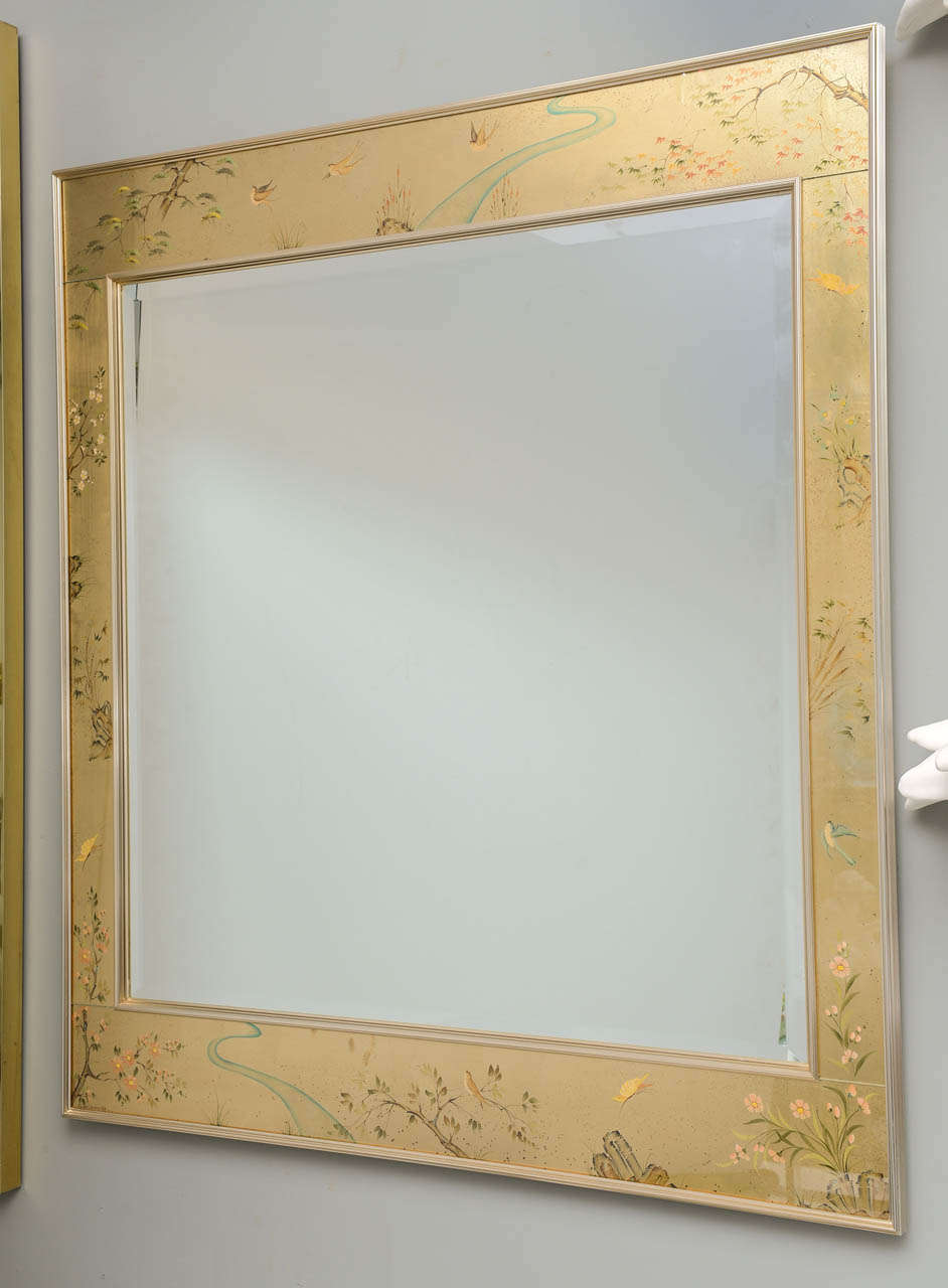 Signed La Barge mirror featuring reversed painted glass with plant life motif and brass edges.