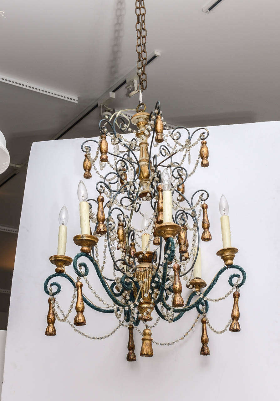 Italian beaded chandelier with hand carved wooden gilt tassels, featuring turquoise colored seed beads, and garlands of clear glass beads. The fixture comprises 19th and 20th century elements. It has seven sockets.