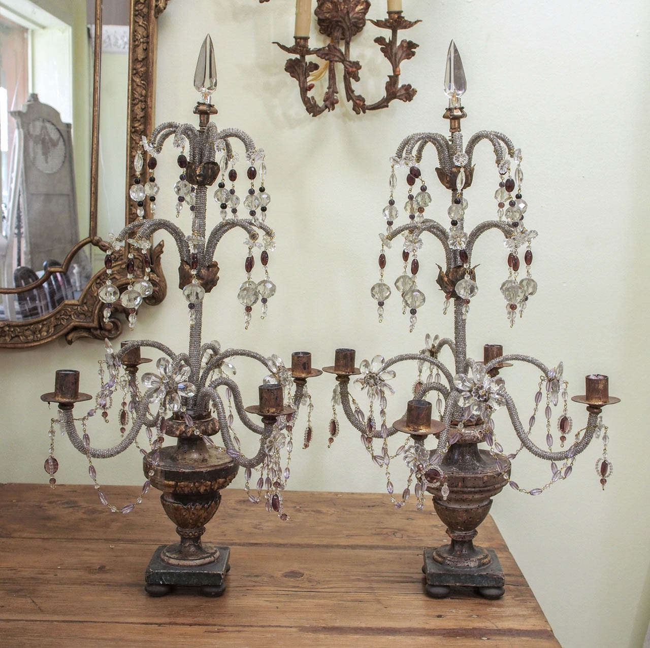 Pair of Italian c. 1880 girondoles.  Four candle arms extend from a central axis mounted on a carved painted and giltwood urn on a square base which is raised on small bun shaped feet.   Beaded crystal ropes encrust the central axis, the surrounding