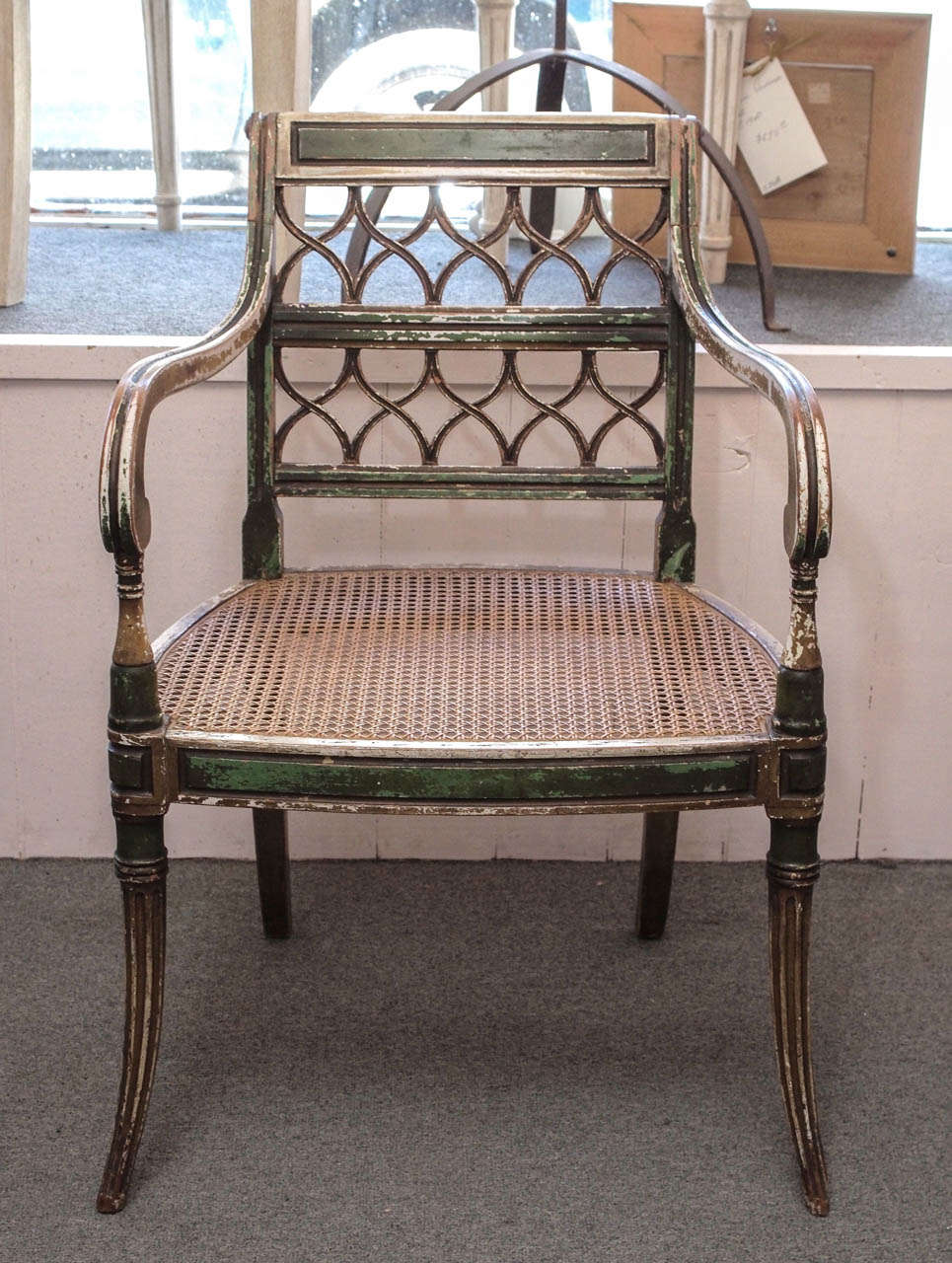 Pair of distressed green and cream painted wood armchairs with cane seats, France c1920.  The legs are gracefully tapered with the front legs being fluted.