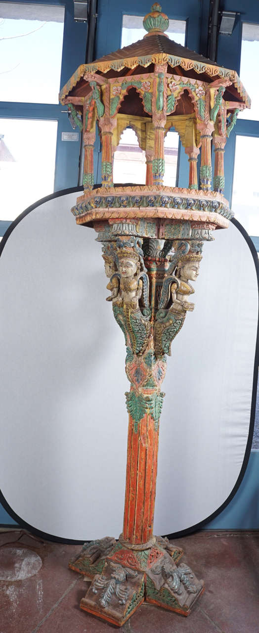 Beautifully hand-carved and hand-painted with florals, acanthus leaves and the top piece being held by intricately carved goddess figures.