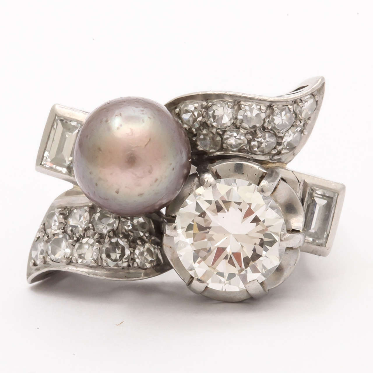 A stunning Retro cocktail ring with a center two carrot diamond and a rare brown natural pearl (8.5mm) wonderfully mounted on an artistic platinum mount with two diamond leaves. GIA certified. With two baguette diamonds flanking the arrangement.