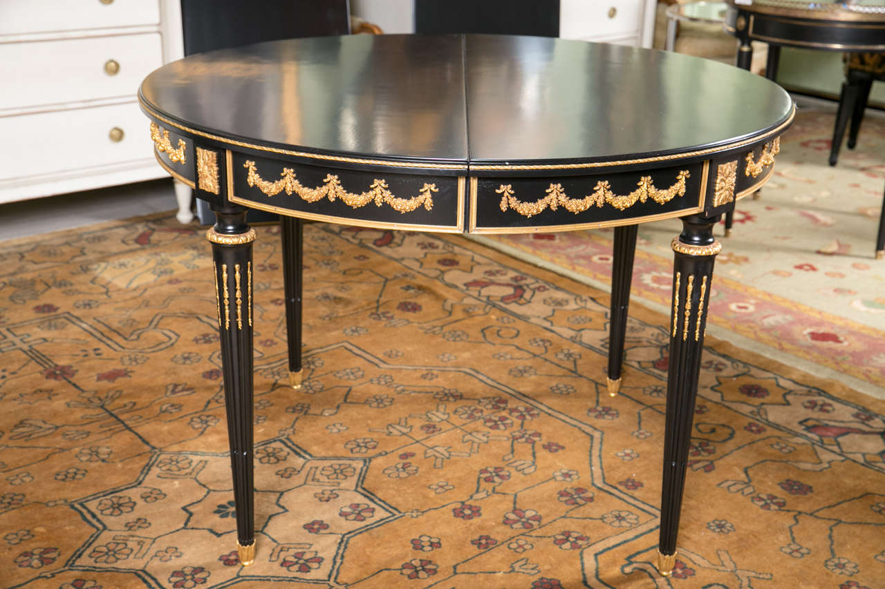 Simply one of the finest French Louis XVI style ebonized dining tables by Maison Jansen having two 19.75