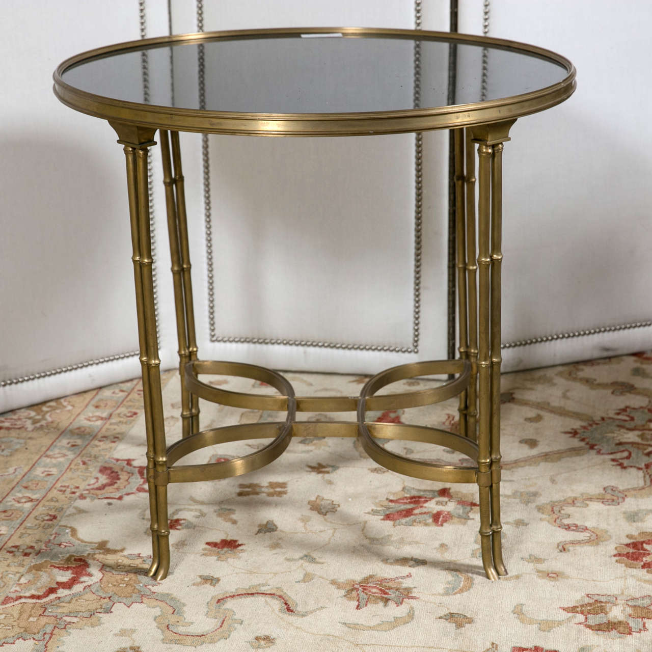 A single marble-top bamboo form bouillotte table. This bronze base of bamboo form having a lower pear shaped undercarriage leading to a group of four legs supporting a bronze framed marble or granite top.