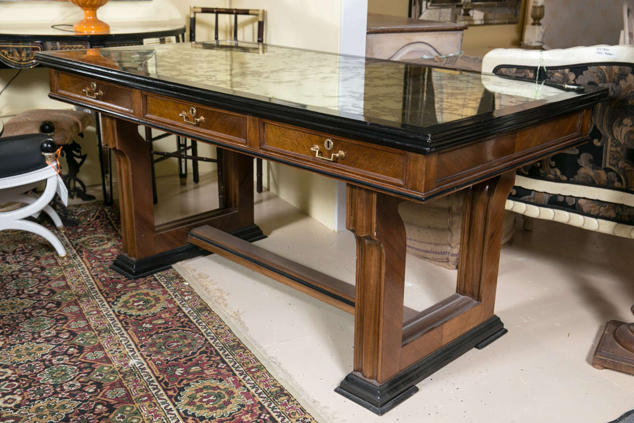 An Art Deco Mirror top mahogany and ebonized desk. This one of a kind desk has a sold mahogany base and top decorated in ebony woods and supports a decorative mirror top of silver and gold veins. The lower knee hole area with plenty of room with