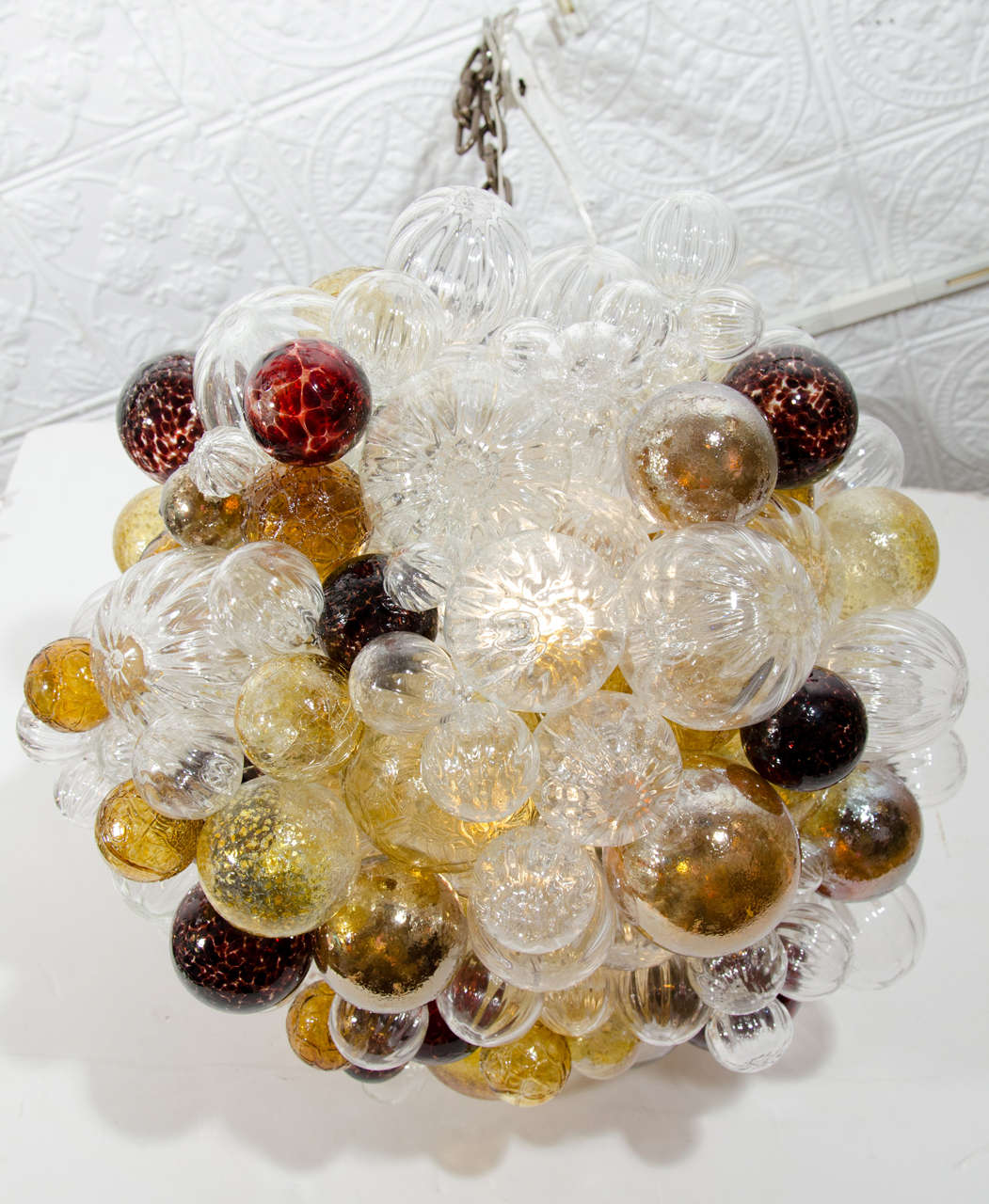 Hand blown glass bubbles in various shades of red, amber and clear, with an adjustable cable and canopy.
Wired and ready to hang.