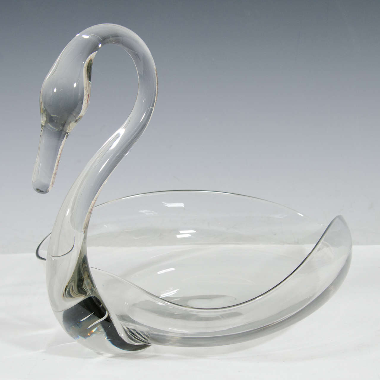 A vintage solid clear glass sculptural dish centerpiece, in the form of elegant swan. Good condition, consistent with age and use.

Two available sold individually.