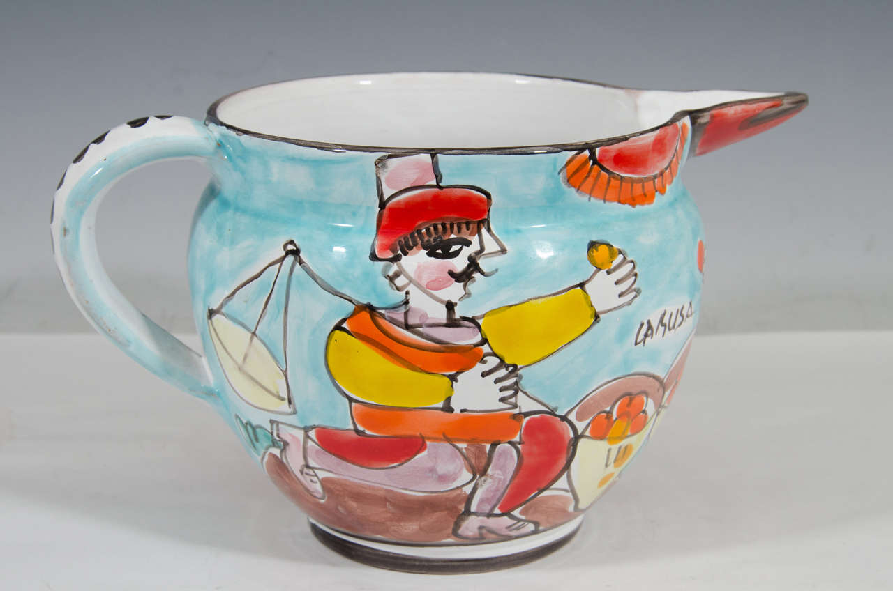 A vintage ceramic pitcher with colorful hand-painted scene of a man and woman with baskets of fruit by La Musa. Good vintage condition with age appropriate wear. A nick to the spout and to the rim.