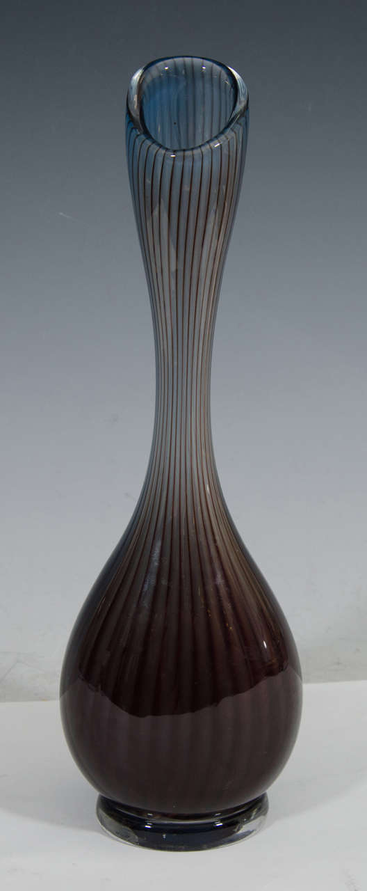 A vintage Kosta Swedish colors art glass bud vase designed by Vicke Lindstrand with an elongated body and decorated with gray and maroon vertical bands on a clear base. Marked LC1 on the bottom.