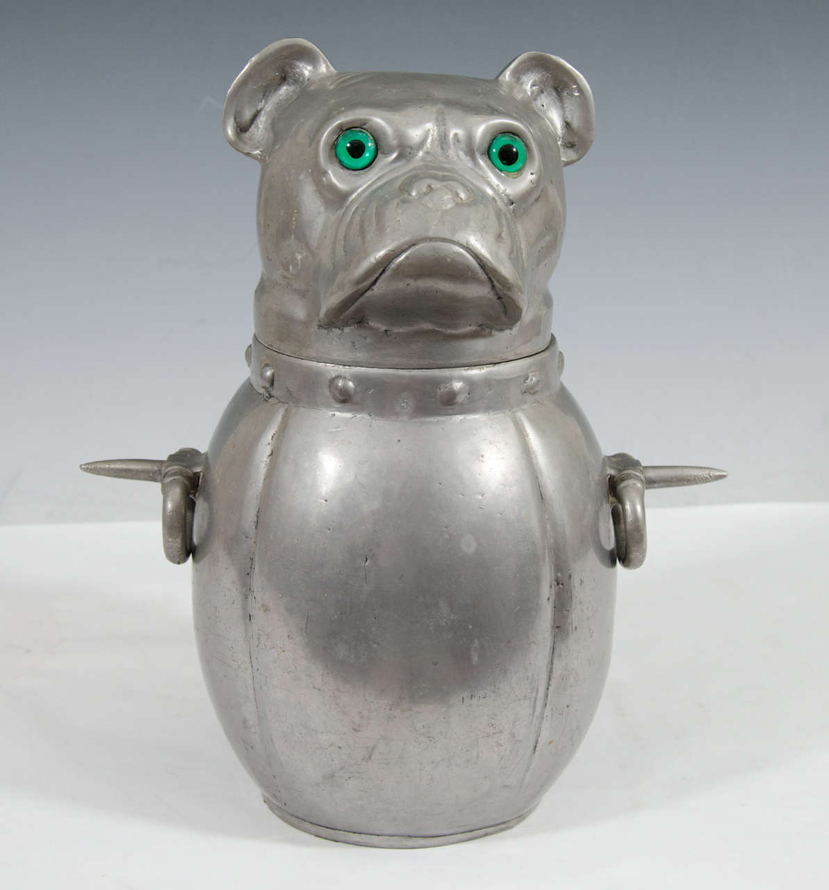 A French pewter ice bucket in the shape of bulldog with bright Green Glass Eyes.A great Bar Accessory for Dog Lovers.A Functional and Compelling piece for your Bar.