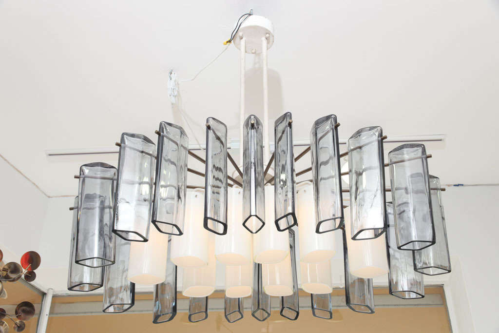 Fine & rare Italian chandelier by Vistosi, Murano, Italy. Unique and wonderfully designed work with thirty (30) large hand blown glass drop vases hanging from twenty (20) matte brass rods and a white enameled metal frame with ten (10) light sockets.
