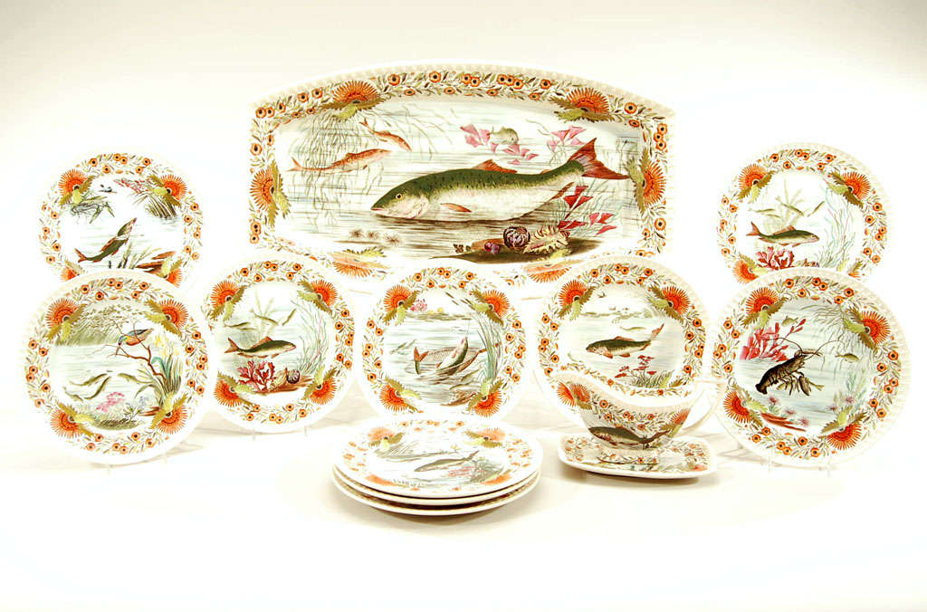 This complete and unusually decorated fish service is painted in the Aesthetic Movement style with all over polychrome enamel. The 12 plates each depict an aquatic scene including a rare lobster. The platter is also beautifully decorated with a full