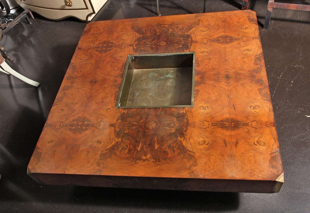 WILLY RIZZO (1928-2013)
Square low table in mirrored burlwood veneer, raised on base.
Brass corner details and center brass bar insert for storage of glasses and liquors.
Italian, c. 1970

13 1/2