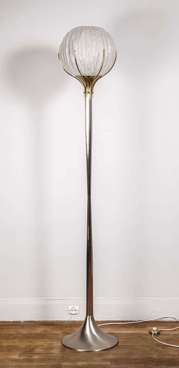 A polished steel and glass floor lamp. The polished steel stem supporting a circular 