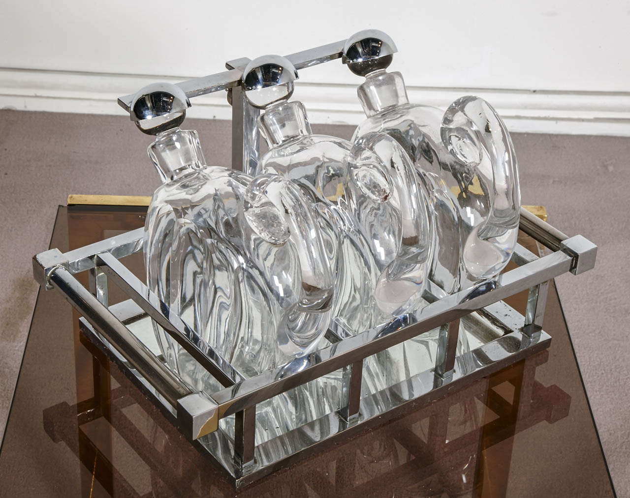 Liqueur cabinet including a tray in the style of Jacques Adnet with three cristal jugs signed Baccarat.

Similar model in the book 'Jacques Adnet' by Alain Rene Hardy and Gaelle Millet. Editions de l'Amateur, Paris 2009, page N°226.