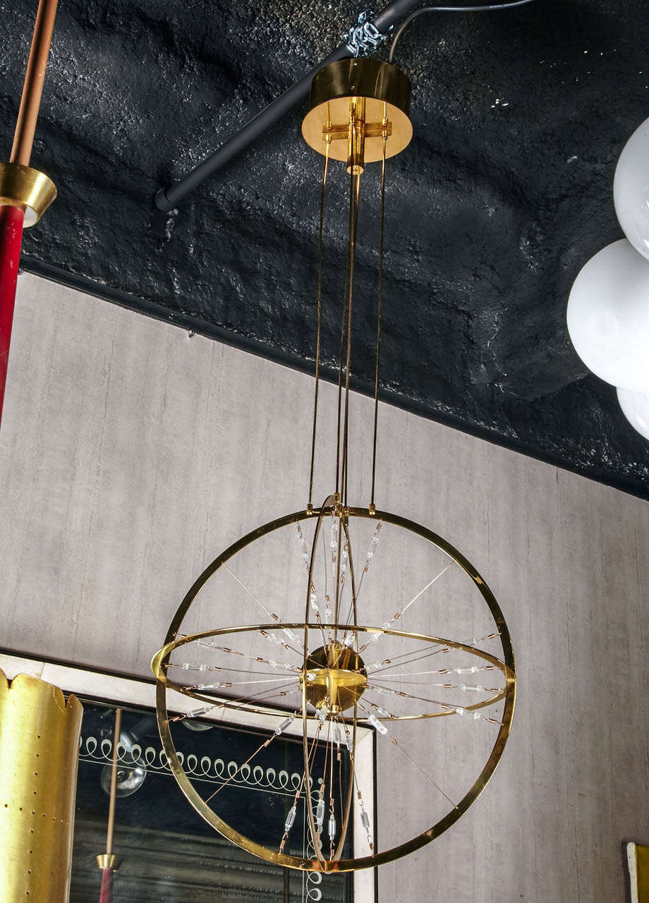 1970's 'Three Rings' gilded brass chandelier with transformer which converts 220 volts to 12 v for 36 halogen bulbs.