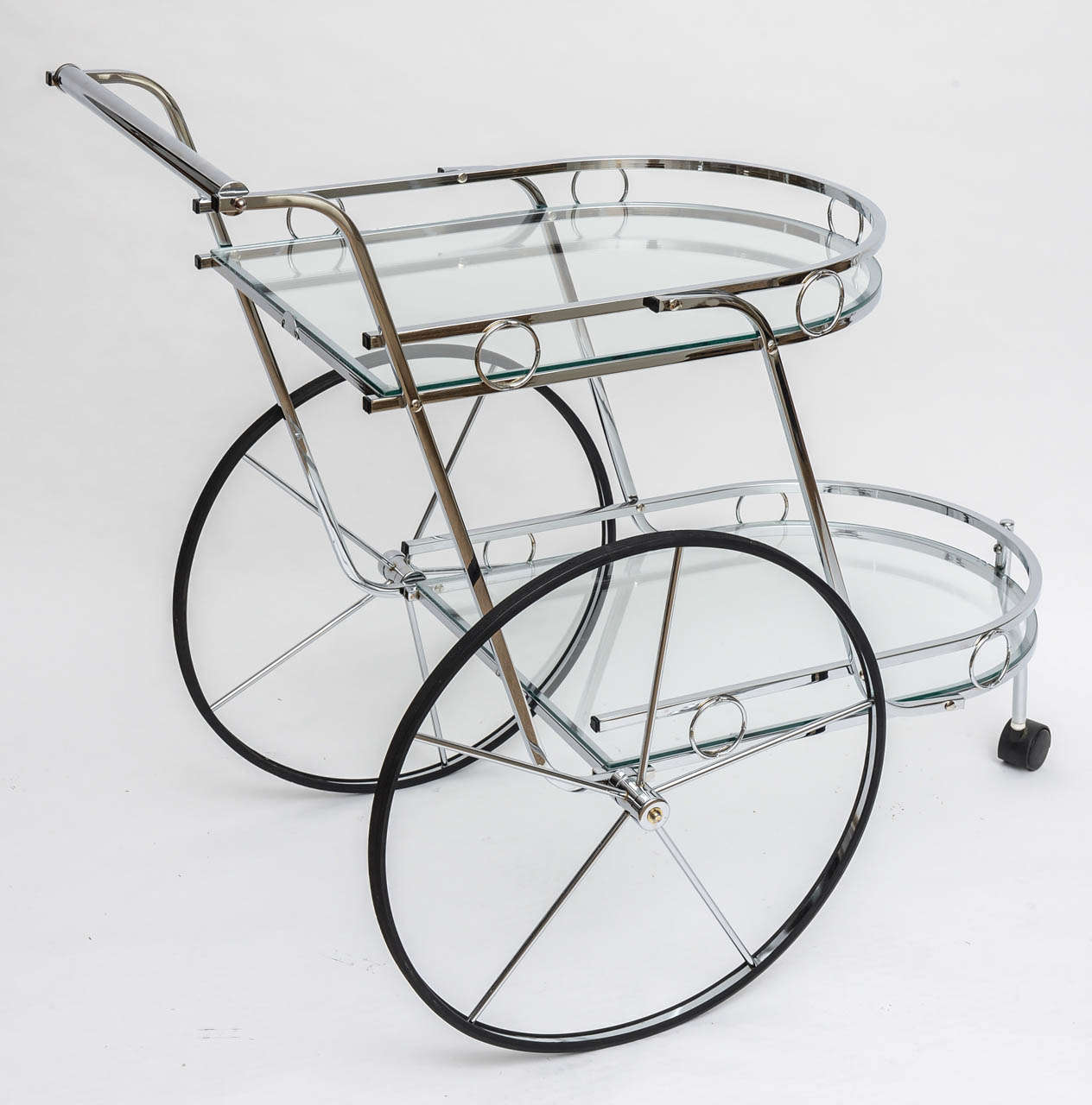 Large rear wheel bar cart fashioned of nickel-plated steel and featuring two glass tiers with curved fronts and straight backs each with decorative fencing. Rolls perfectly and very attractive and fun great for those swanky martini soirees.