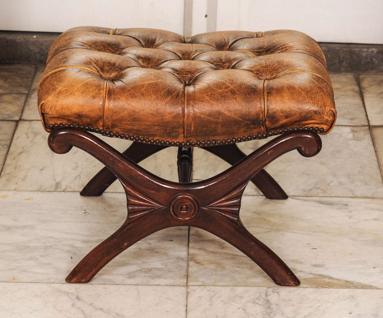 A pair of English Regency-style mahogany and stools or taborets with leather upholstered.