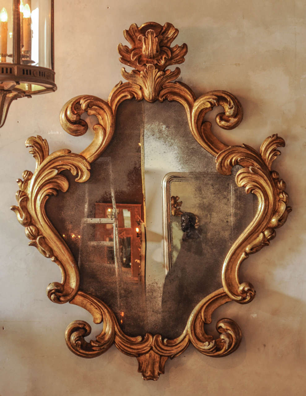 A large 18th century Italian Baroque carved giltwood mirror with weathered mirror glass.
