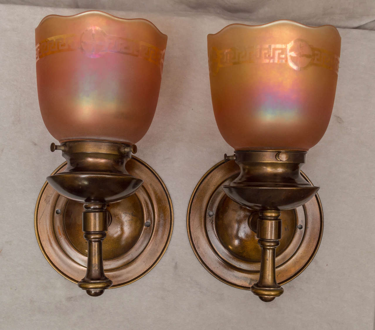 The theme here is, simple and elegant. These handsome sconces are made of brass, and hold up a beautiful pair of signed 
