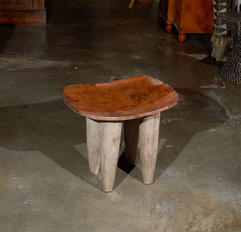 African stool from the Ivory Coast and the Senufu tribe, the curved seat raised on four tapering legs. 