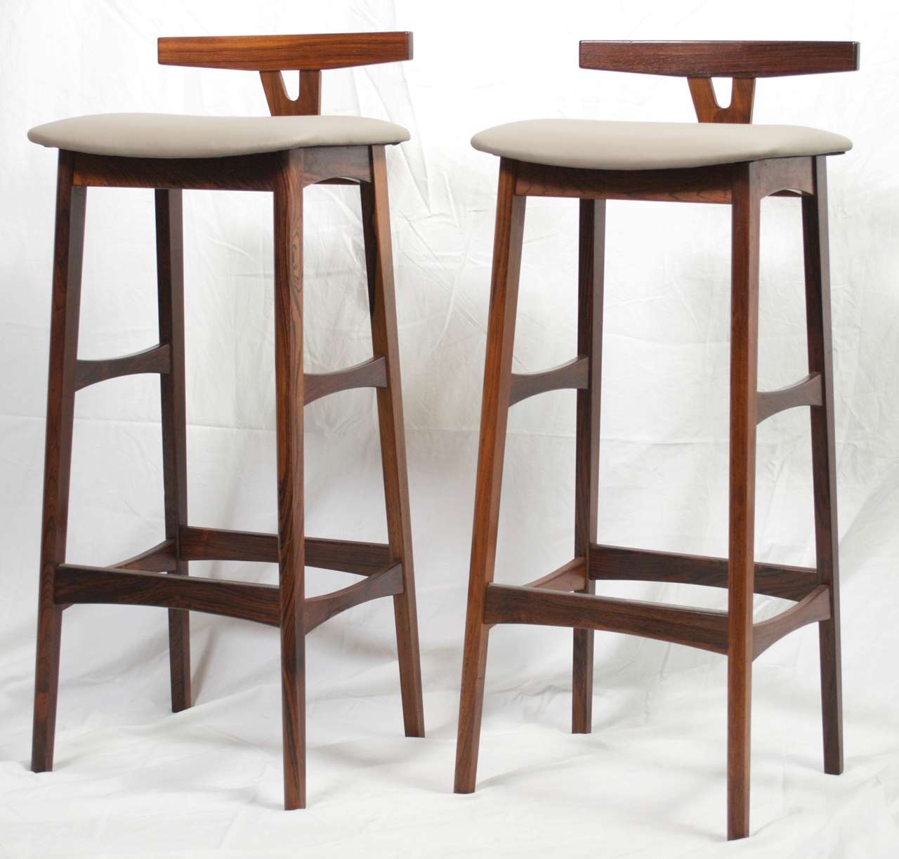 For your consideration is this handsome pair of 1960's vintage Danish Modern bar stools in rosewood by Dyrlund.  These mid century stools have new padding and have been professionally reupholstered in grey leather. The rosewood is in well kept