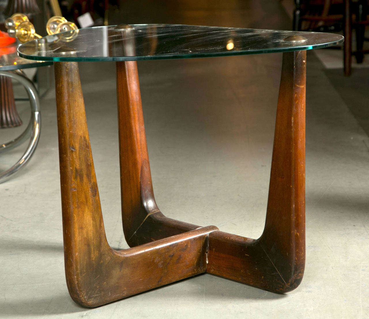Sleek mid century design table in the style of Finn Juhl.
Brass caps on tips supporting glass top.