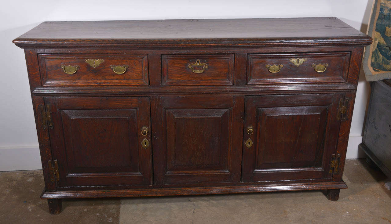 18th century oak Welsh dresser base with three drawers and three cabinet doors. All original hardware and beautiful wood patina.