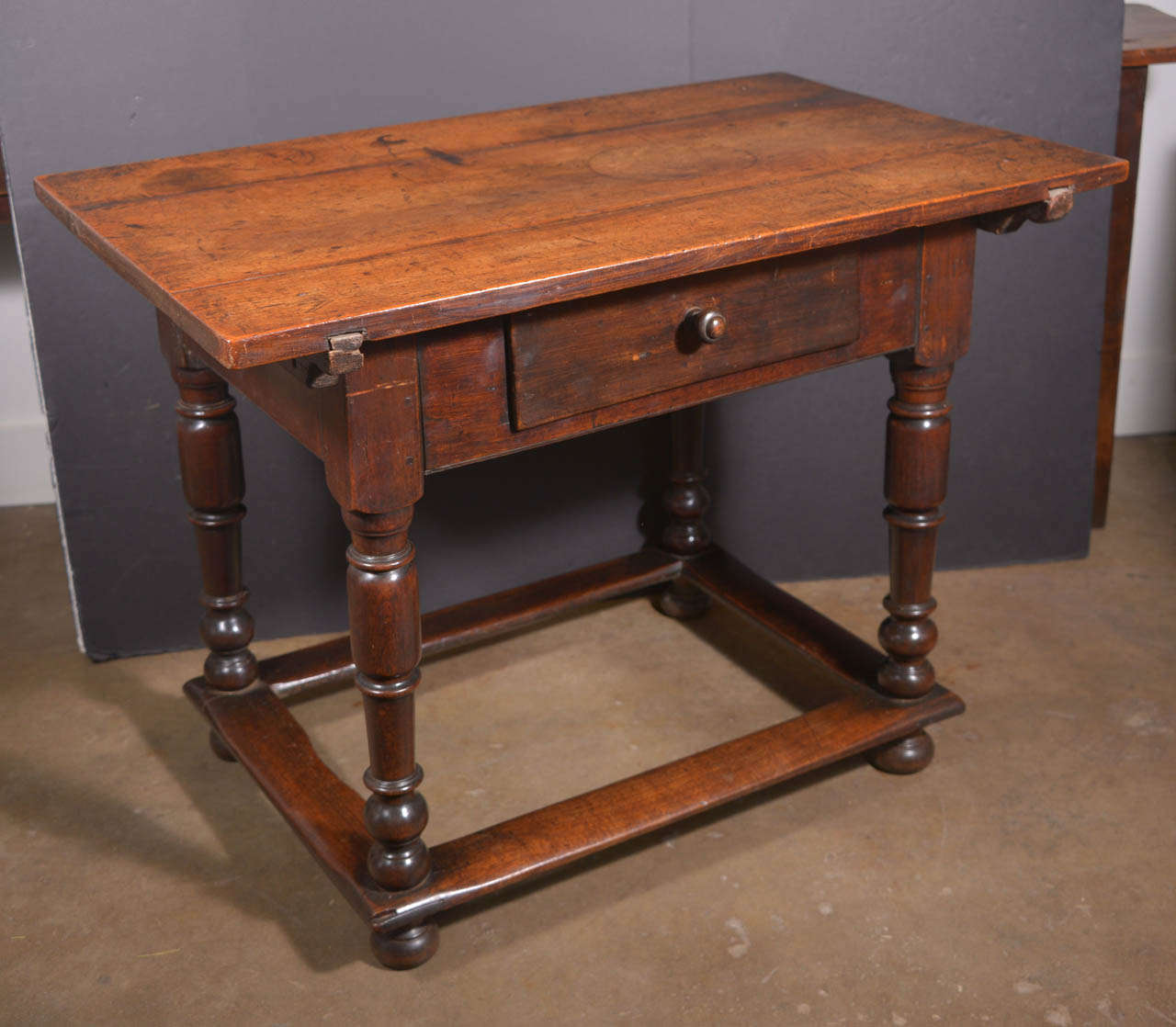 Beautiful Walnut table with a moveable top used to store rents.  Wonderful stretcher connecting all four legs at base.