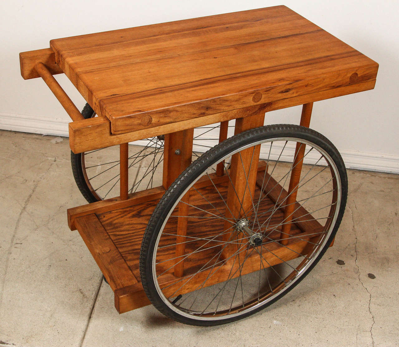 Rolling bar cart by Bill Sanders with wood and bicycle wheels, 1964.