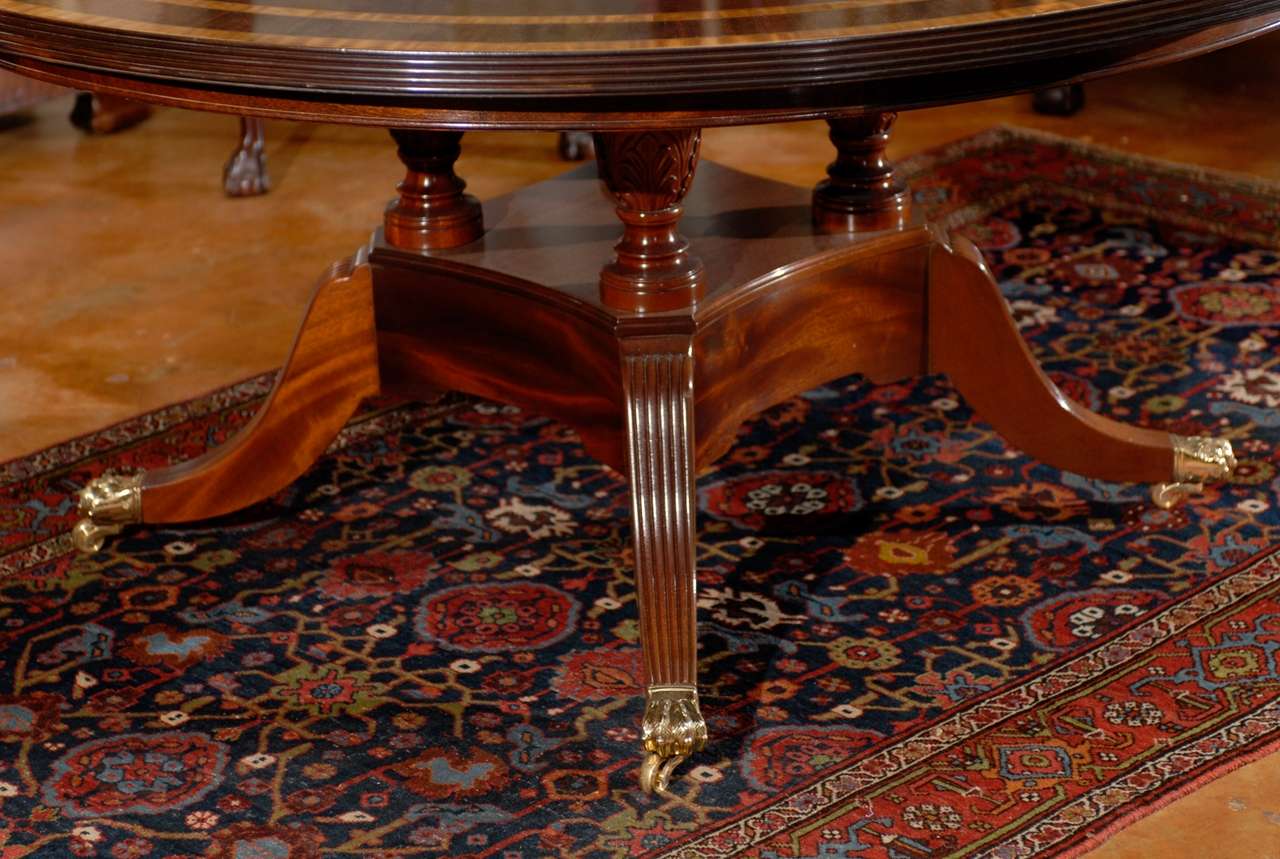 English Sheraton Mahogany round dining table with triple banded top of satinwood and rosewood. The 1.5