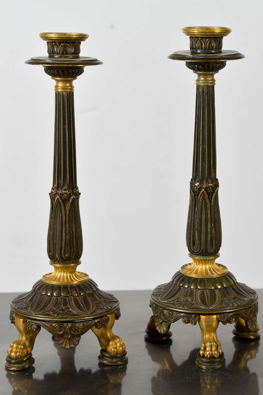 Pair of Neoclassical bronze and gilt bronze candlesticks, with mounted claw feet
English, early 19th Century
11-1/4
